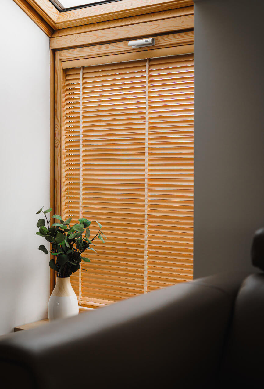 Żaluzje bambusowe na oknie dachowym z doniczką rośliny